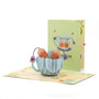 Best Teas 3D pop-up card front view: Me and You tea bags in a blue teacup, green cover behind, everpop